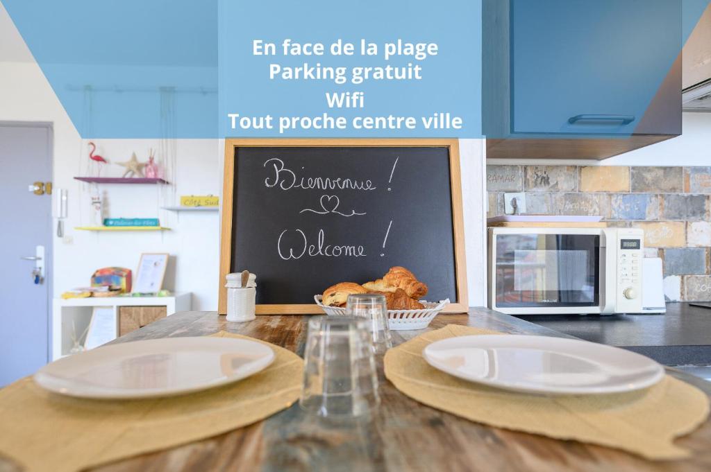 a kitchen counter with two white plates on a table at Côté Sud in Palavas-les-Flots