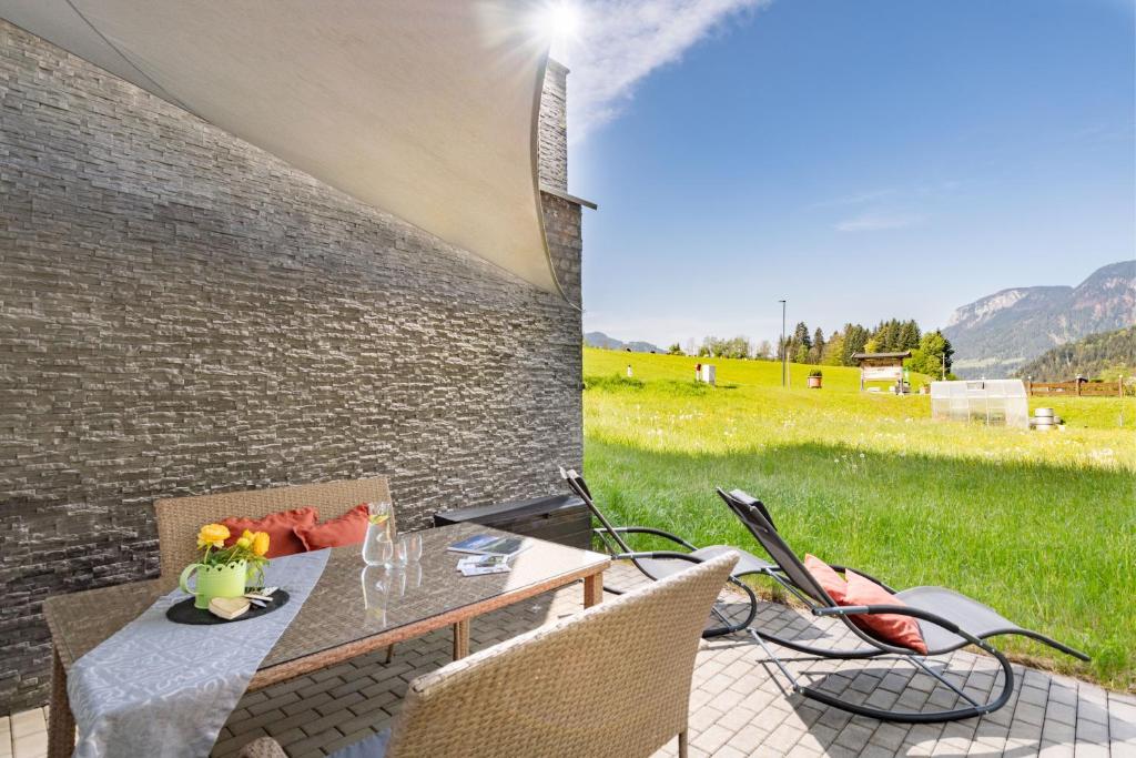 um pátio com uma mesa e cadeiras com vista para um campo em AW - Apartment Wilder Kaiser em Scheffau am Wilden Kaiser