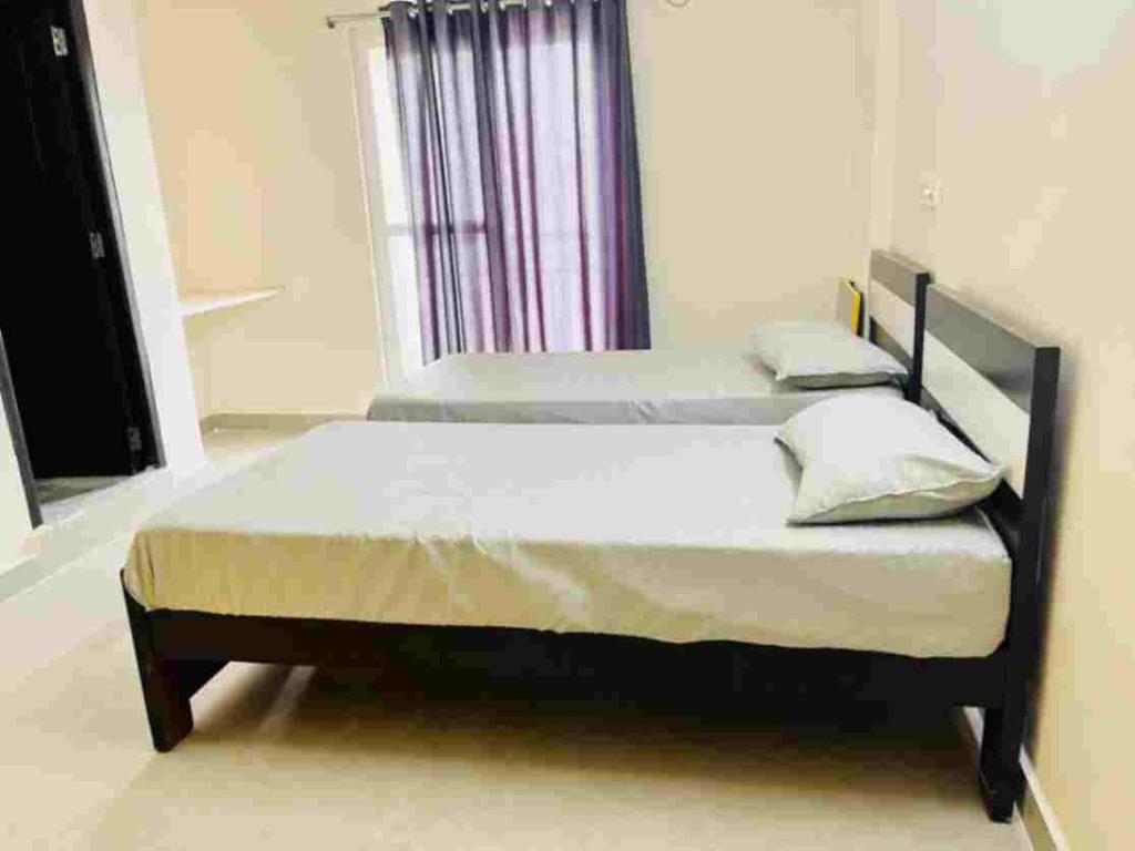 2 Betten in einem Schlafzimmer mit Fenster in der Unterkunft Stay In Hotels and Resorts in Hyderabad