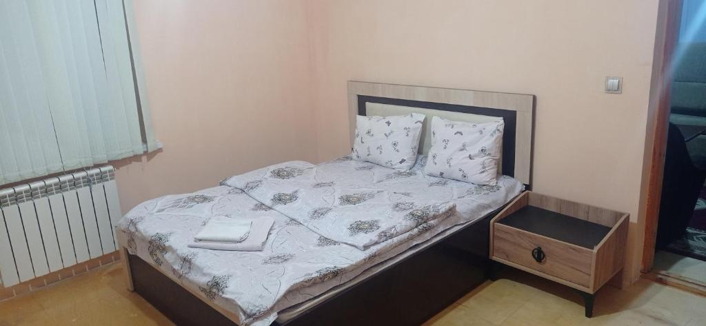 a small bedroom with a bed with a wooden box at Sərin göl istirahət mərkəzi in Quba