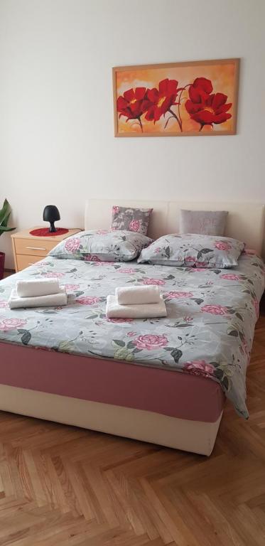 a bedroom with a bed with a floral bedspread at Apartment JANDA - Zadar Croatia in Zadar