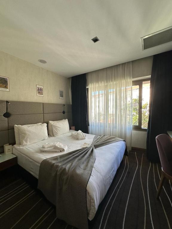 a bedroom with a large white bed with a window at Cihangir Hotel Bosphorus in Istanbul