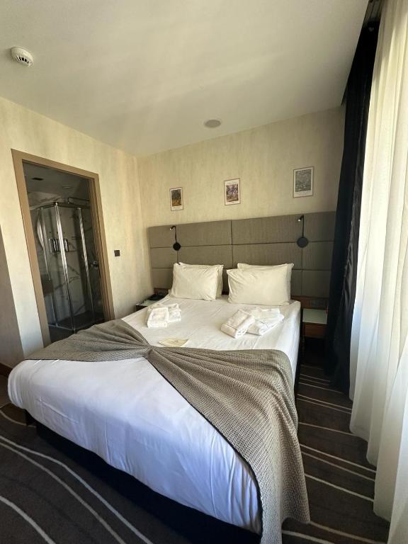 a bedroom with a large bed with white sheets and pillows at Cihangir Hotel Bosphorus in Istanbul