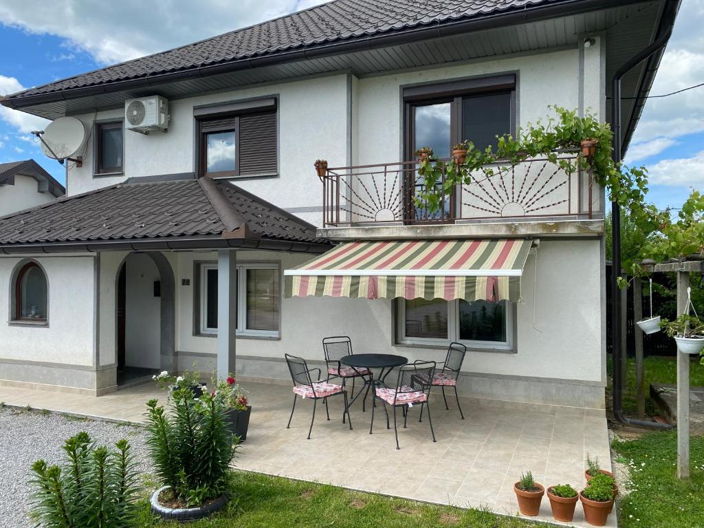 a patio with a table and chairs in front of a house at Kuća za odmor Tarik in Cazin