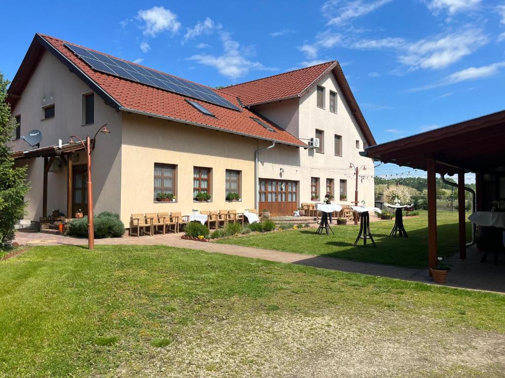 a large white building with a red roof at Bozsity Vendégház in Üllés