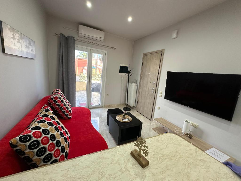 a living room with a red couch and a flat screen tv at Studio One in Kanálion