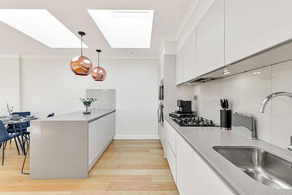 cocina blanca con fregadero y encimera en 2 Bedroom Penthouse in Brentford, en Brentford