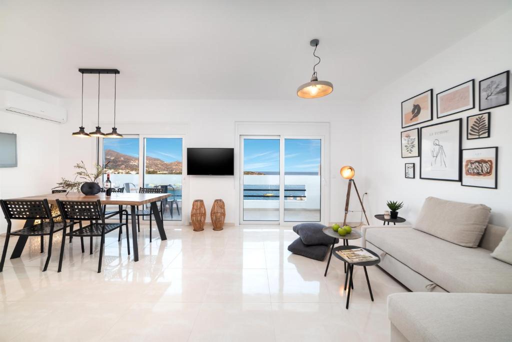 uma sala de estar branca com uma mesa e um sofá em Loft 57 em Agios Nikolaos