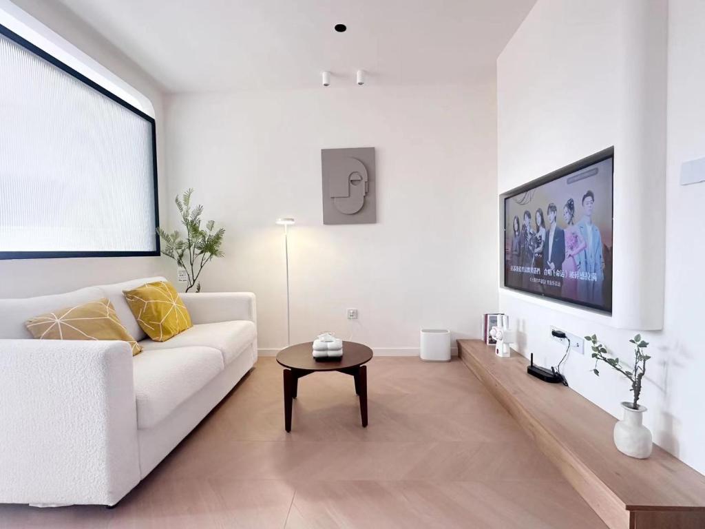 a white living room with a white couch and a table at 同济佳苑公寓 in Shanghai