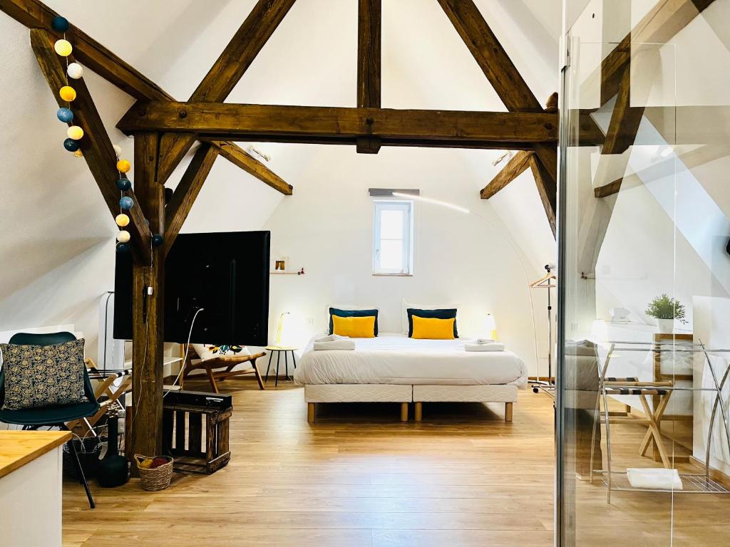 a bedroom with a bed in a room with wooden beams at Le Loft in Colmar