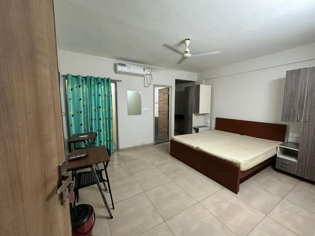 a bedroom with a bed and a desk in it at POP 82272C Townhouse Oak- Seven Olives in Bangalore