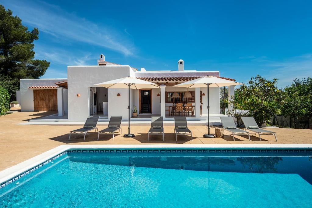 uma villa com piscina em frente a uma casa em Can Joan Durban em Sant Joan de Labritja