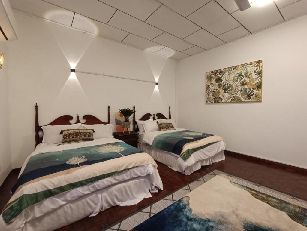 1 dormitorio con 2 camas y un cuadro en la pared en SOHO STAY, en Kuala Terengganu