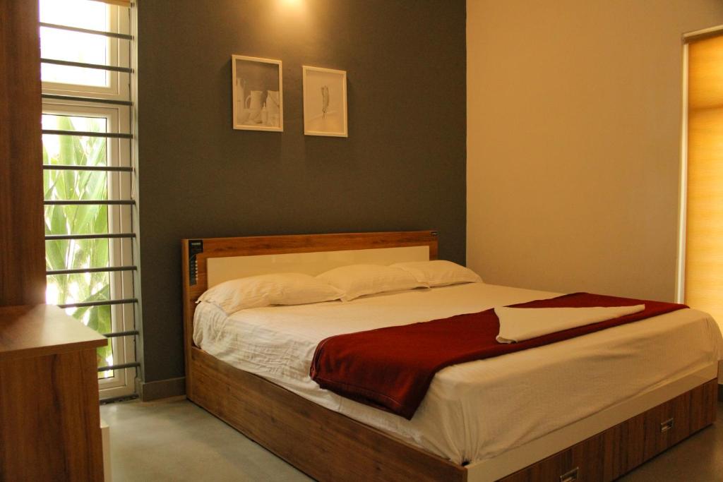 sypialnia z dużym łóżkiem z drewnianą ramą w obiekcie CuteHug Home stay w mieście Kalpatta
