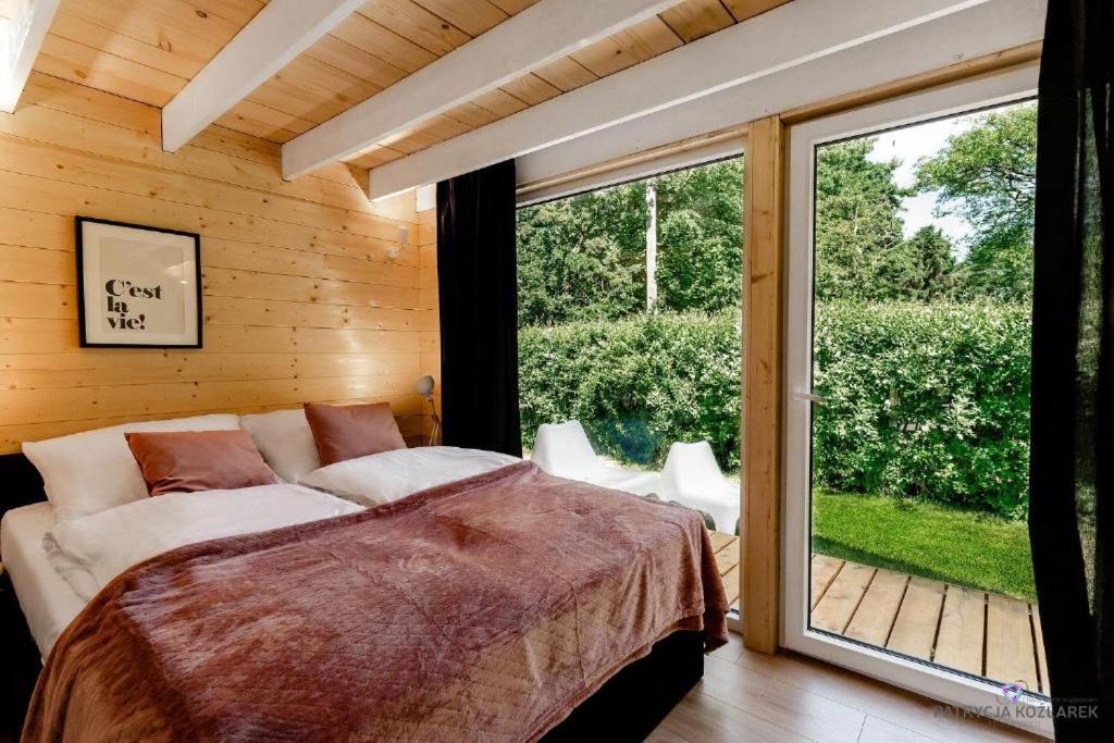una camera con un letto e una grande finestra di Trzy Domki w Mielnie a Mielno