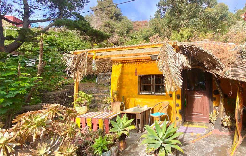 een geel huis met een tafel en stoelen ervoor bij Studio Mazo La Habitación in Lodero