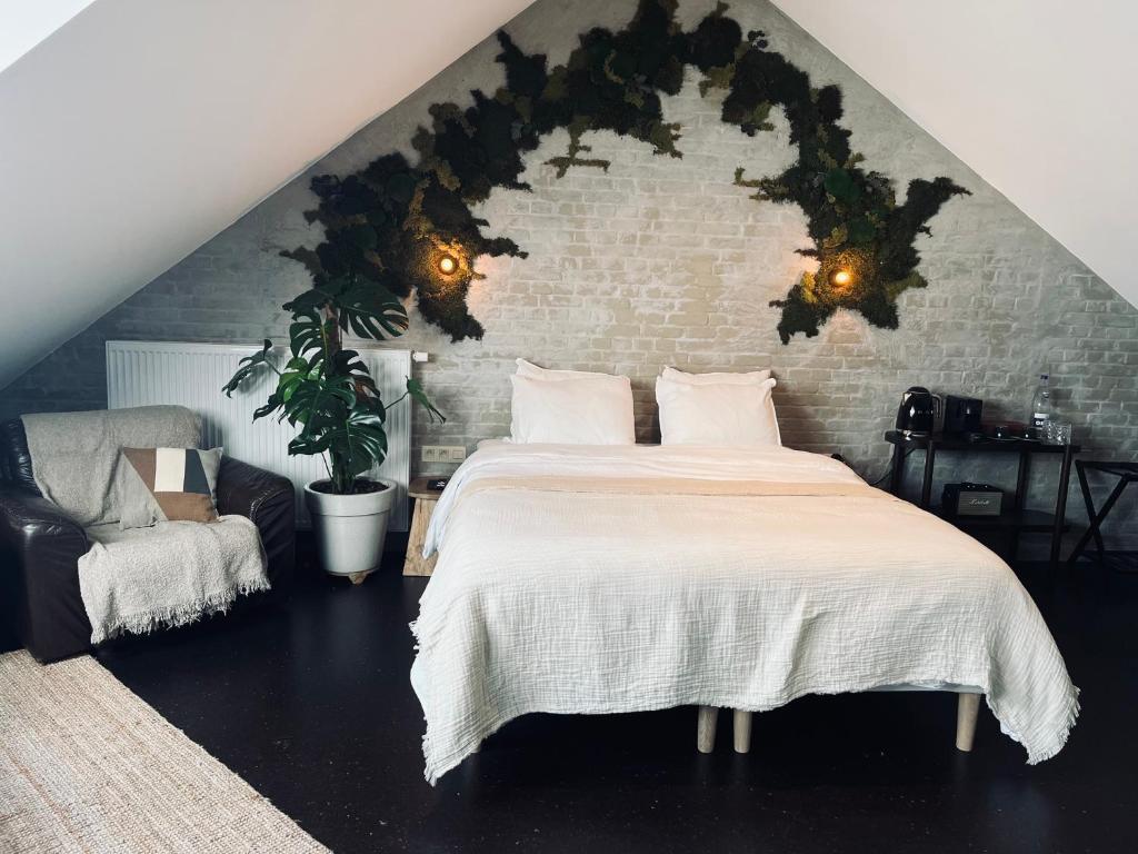 a bedroom with a large bed and a brick wall at La Grainerie in Durbuy
