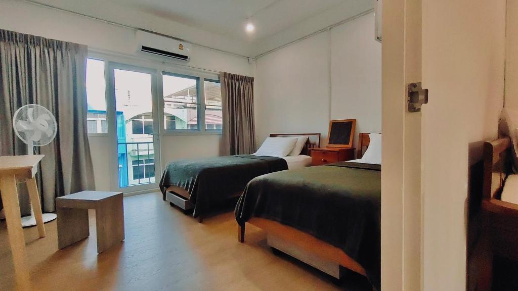 a hotel room with two beds and a window at Whole 3-storey house right in the local community. in Bangkok