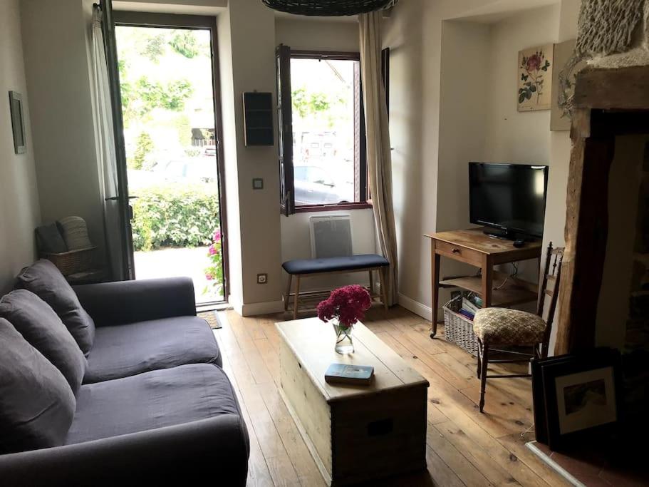 a living room with a couch and a table at La Petite Maison à Beaulieu in Beaulieu-sur-Dordogne