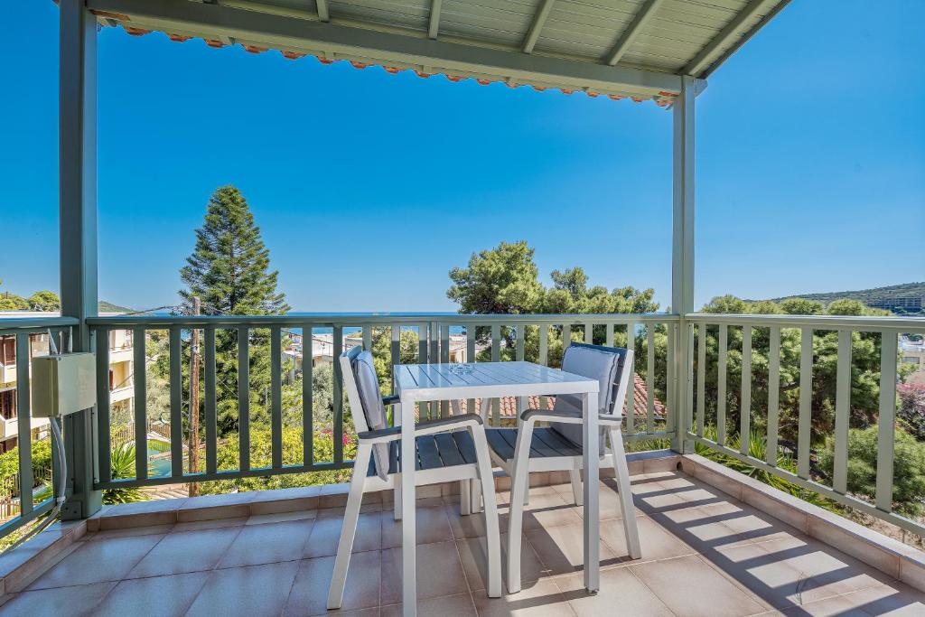 a table and chairs on the balcony of a house at 123 Soleil Studios in Agia Marina Aegina