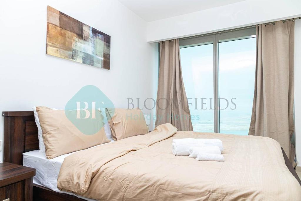 um quarto com uma cama e uma janela grande em Bloomfields - 1br Amazing Sky View At Gate Tower em Abu Dhabi