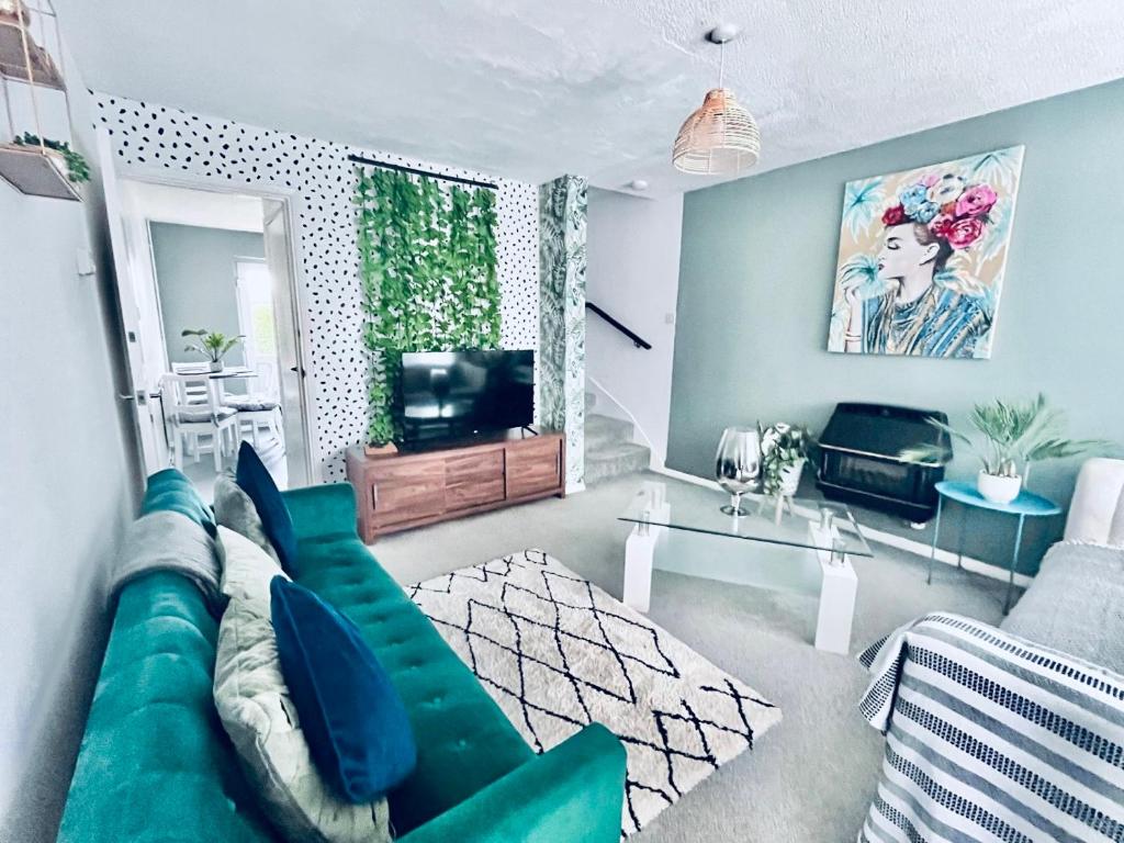 uma sala de estar com um sofá verde e uma televisão em Holiday Home in Canterbury em Kent