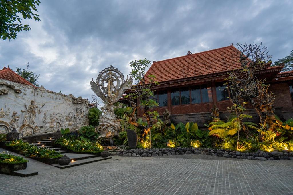 a building with a garden with lights in front of it at Kristana Art and Culture Resort, ARTOTEL Curated in Ubud