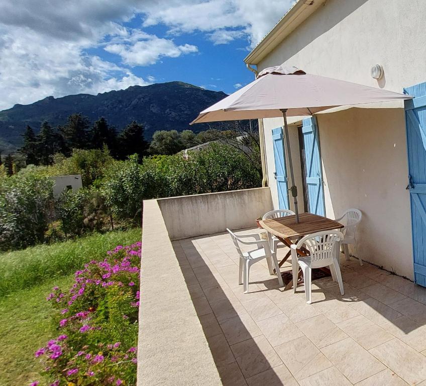 une table et des chaises avec un parasol sur une terrasse dans l'établissement PARADISU, à Biguglia