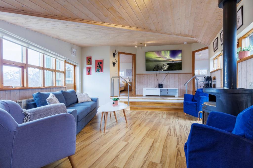 a living room with blue couches and a tv at Cabin Úthlíð - Birta Rentals in Úthlid