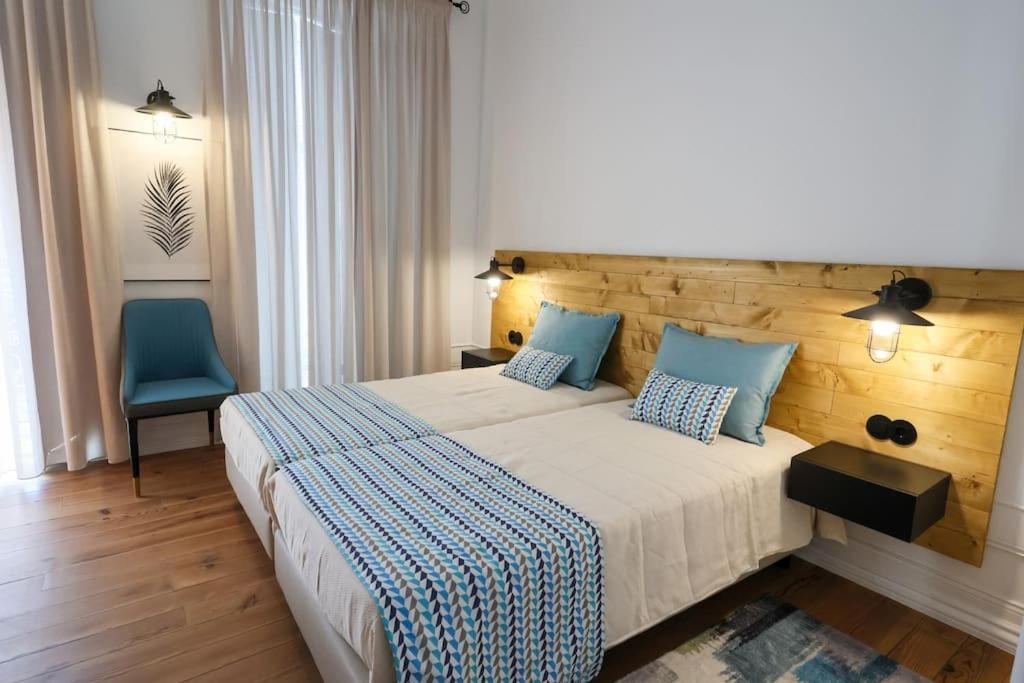 1 dormitorio con 1 cama grande y 1 silla azul en Casa Matriarca, en Santa Comba