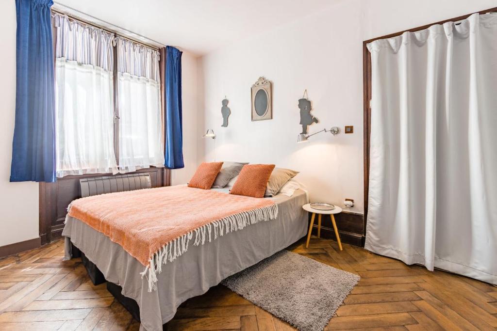 une chambre avec un grand lit avec des rideaux bleus dans l'établissement Studio François 1er, à Amboise