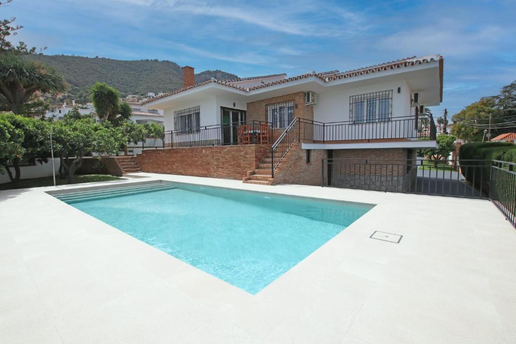 a swimming pool in front of a house at TESS Villa Paz in Alhaurín de la Torre