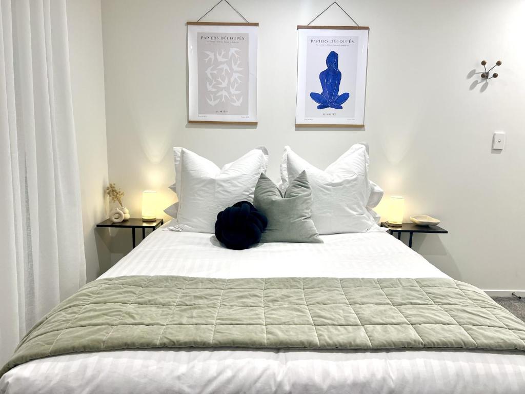 ein Schlafzimmer mit einem weißen Bett mit weißen Kissen in der Unterkunft Wheturangi Urban Escape in Auckland