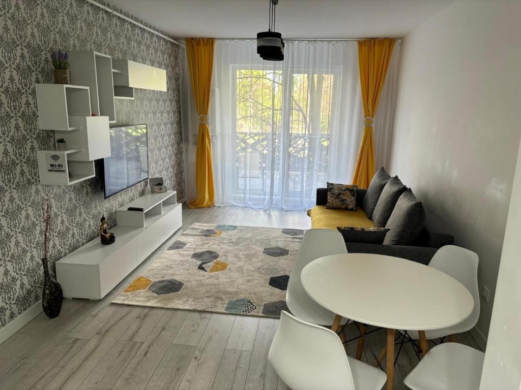 a living room with a white table and a couch at White DeLuxe Apartment in Ploieşti