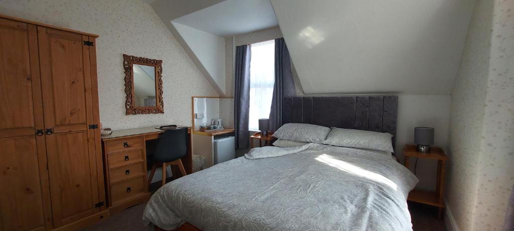 1 dormitorio con cama, escritorio y ventana en Invernook en Newquay