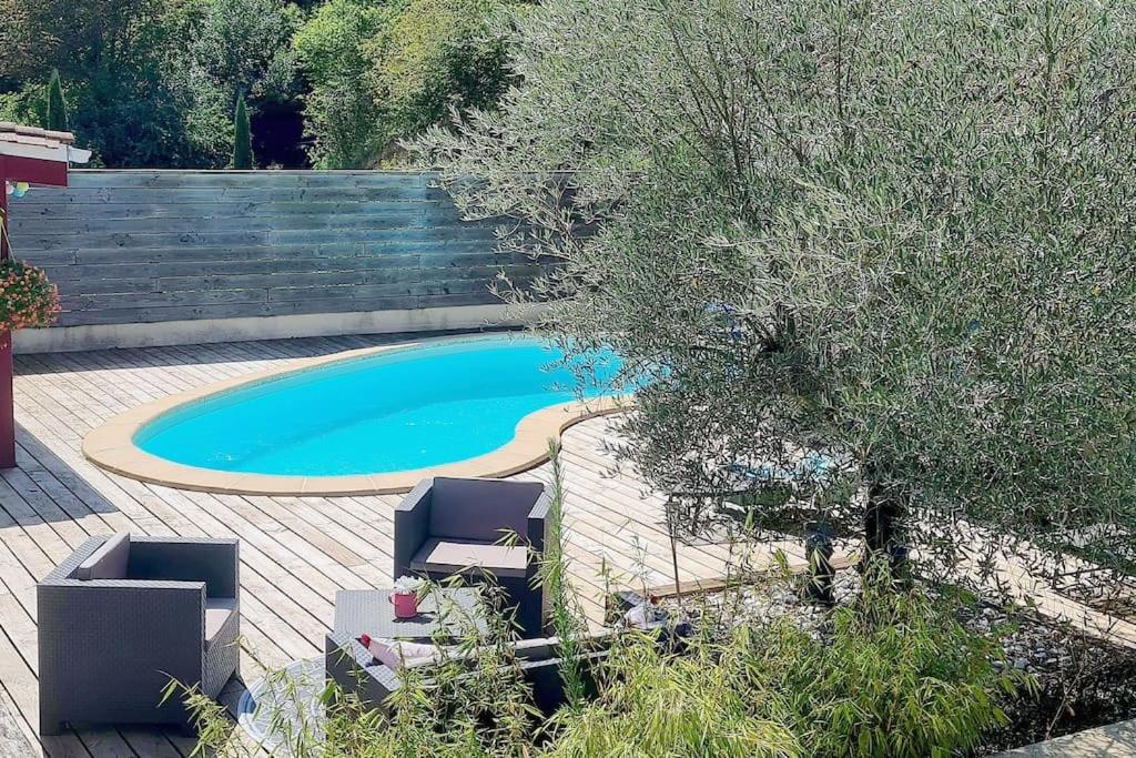 una piscina con due sedie a sdraio e una recinzione di studio de 36m2, a Touvre