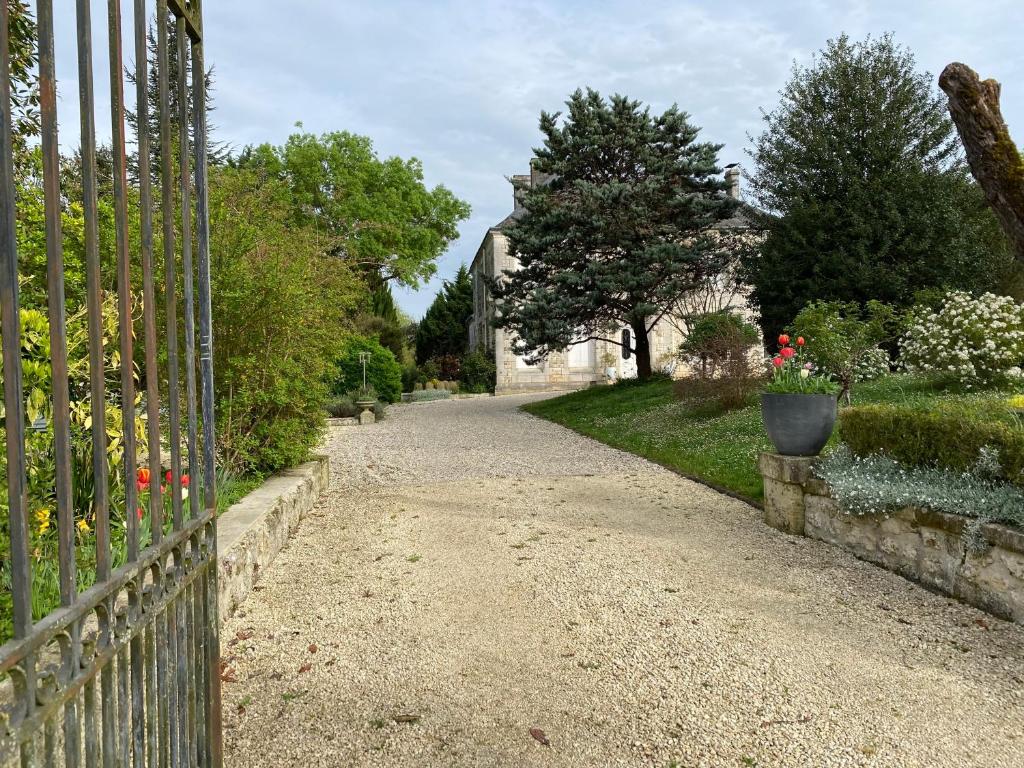 uma entrada que leva a uma casa com uma cerca em Domaine de la Perthuiserie em Saint-Porchaire