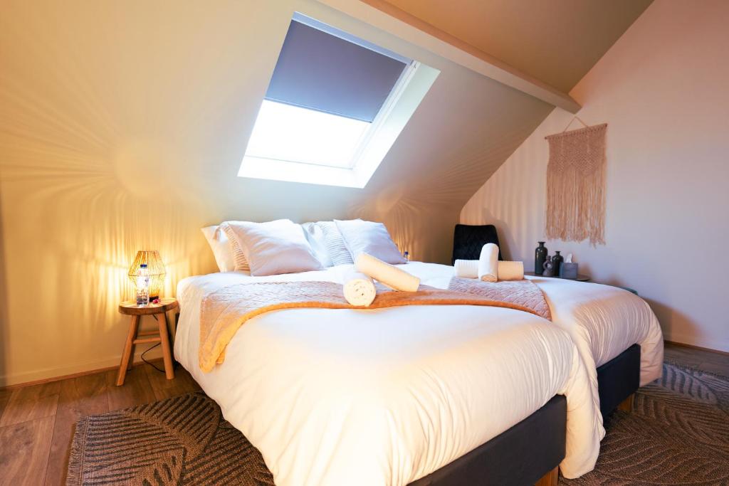 a bedroom with a large white bed with a skylight at Lets Relax - Coté Nature in Mons