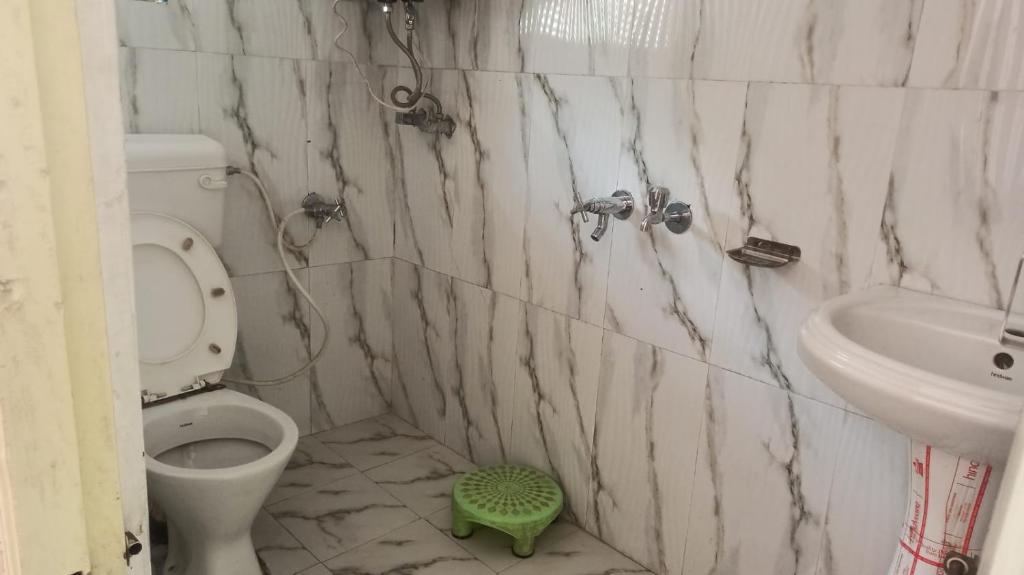 La salle de bains est pourvue de toilettes et d'un lavabo. dans l'établissement Badrinath Govindghat Prithvi yatra hotels, à Badrinath