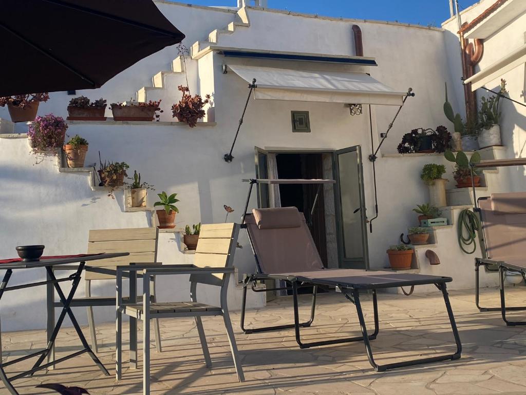 un patio avec des tables et des chaises en face d'un bâtiment dans l'établissement Il Trullo di Loa ad Ostuni a soli 10km dal mare, à Ostuni