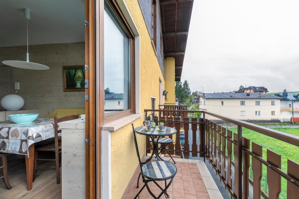 a balcony with a table and chairs and a window at Appartamento Merida6 - Asiago in Asiago