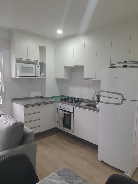 a kitchen with white cabinets and a white refrigerator at All Liberdade (Liberdade/Se) in Sao Paulo