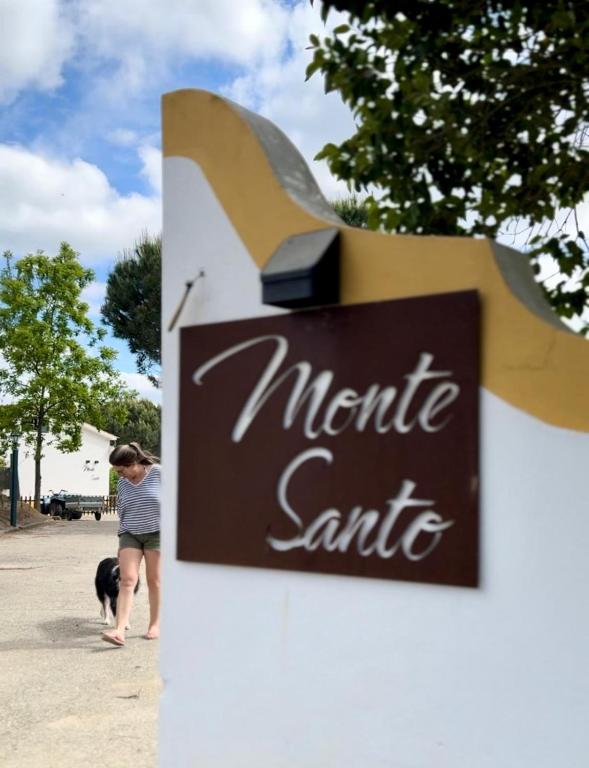 a woman standing next to a sign with a dog at Monte Santo in Montargil