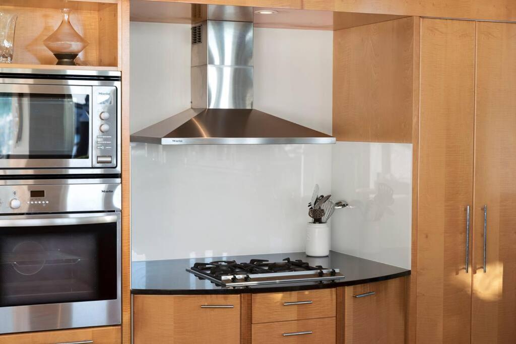 a kitchen with a stove and a microwave at Pavillions 17 Waterfront with Private Pool and Buggy in Hamilton Island