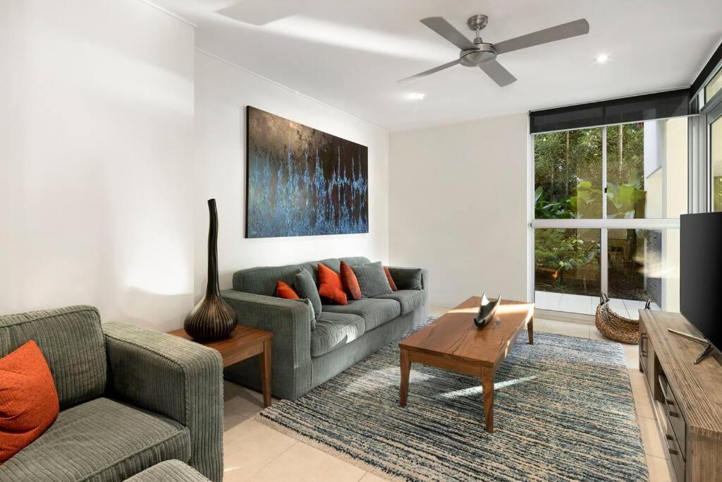 a living room with a couch and a tv at Pavillions 17 Waterfront with Private Pool and Buggy in Hamilton Island
