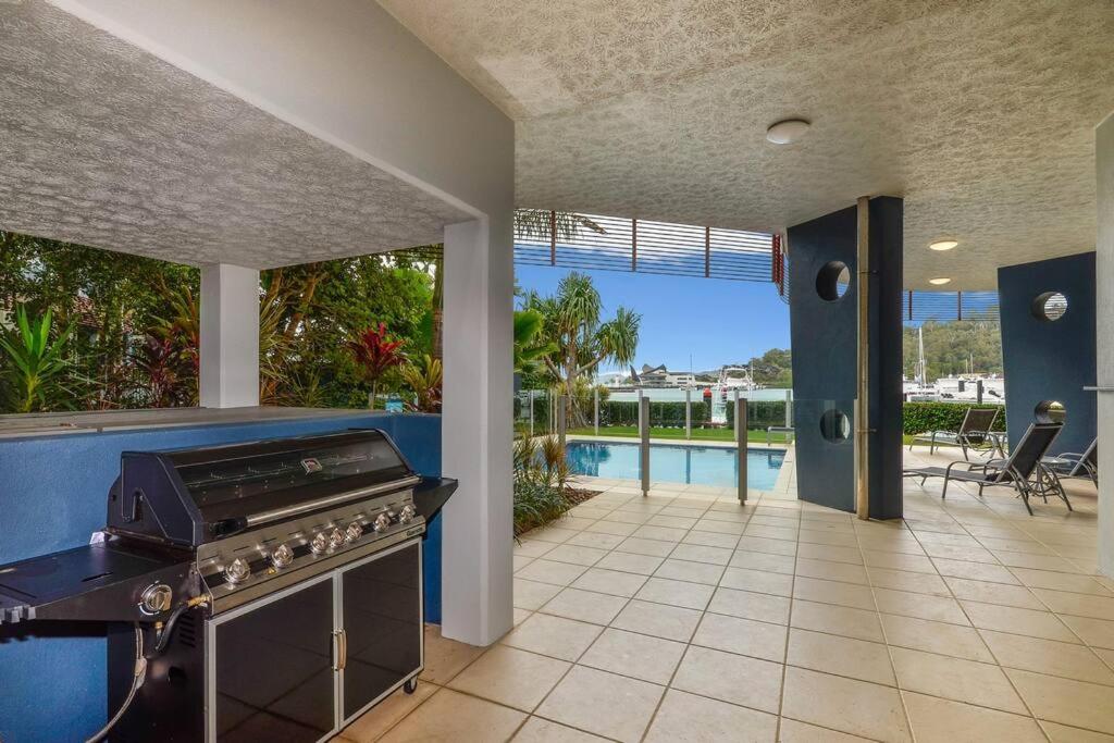 a kitchen with a stove and a view of a pool at Pavillions 17 Waterfront with Private Pool and Buggy in Hamilton Island