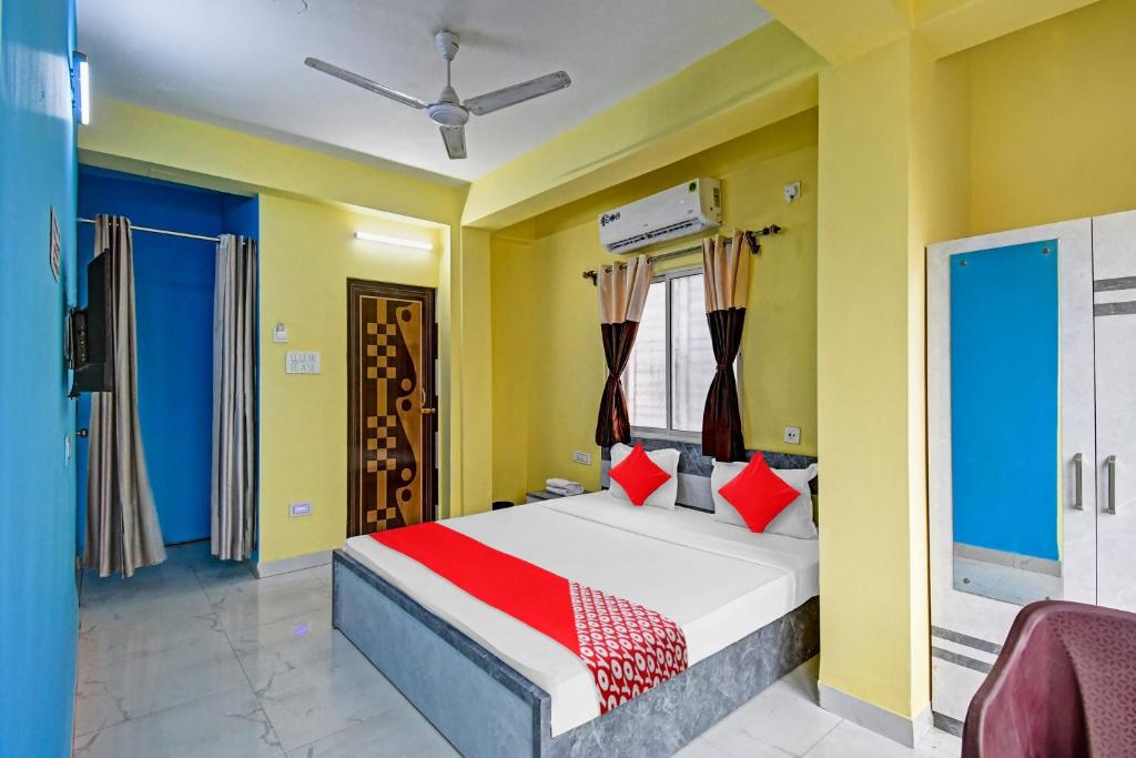 een slaapkamer met een bed met rode kussens bij Collection O Hotel 7dayz Inn Near City Centre 2 in Calcutta