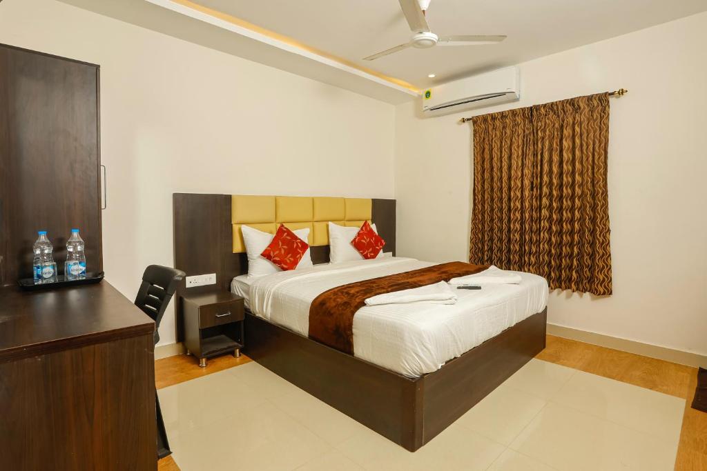 拉梅斯沃勒姆的住宿－Rameswaram Harish Palace，一间卧室配有一张床、梳妆台和书桌