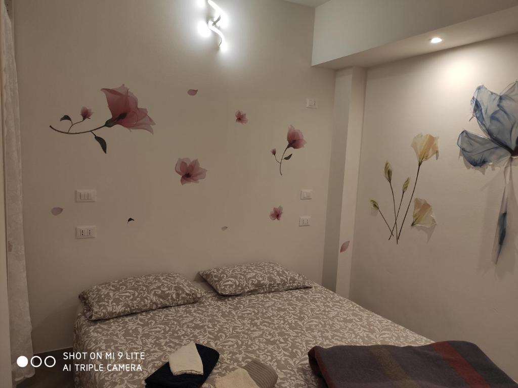1 dormitorio con 1 cama con flores en la pared en Romantic house posto auto aria condizionata, en Bolonia
