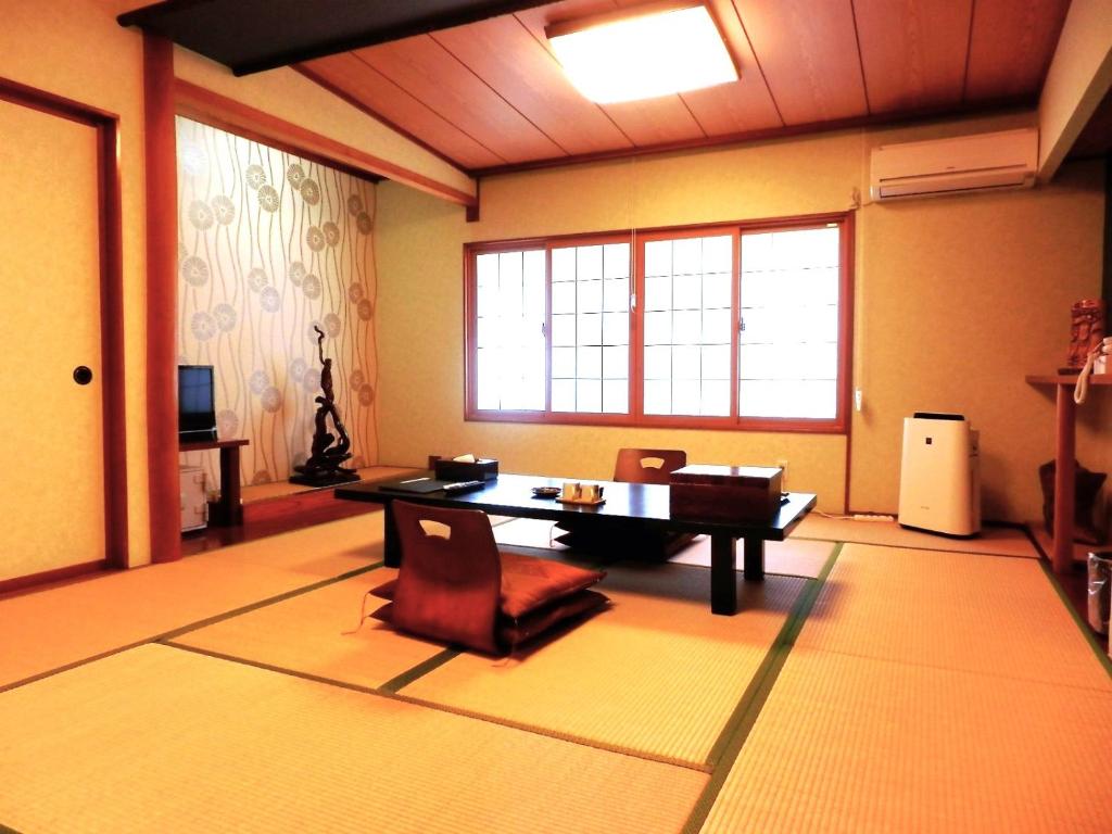 een woonkamer met een tafel en stoelen. bij Tenryuso in Ōtaki